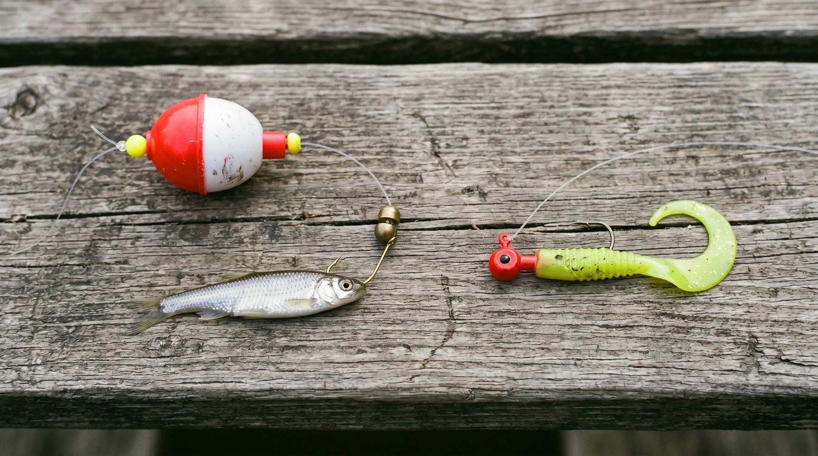 Two crappie fishing rigs on a dock: bobber and minnow setup on the left, chartreuse jig head with soft plastic on the right